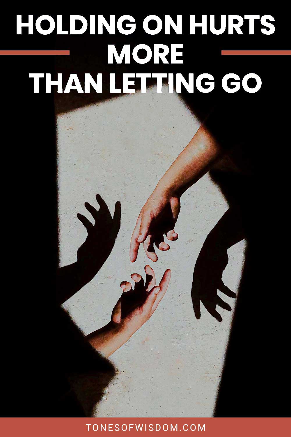 Two hands almost touching each other casting shadow on a wall - Holding On Hurts More Than Letting Go